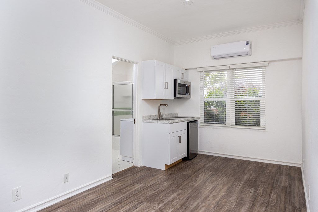 an empty room with a kitchen and a window