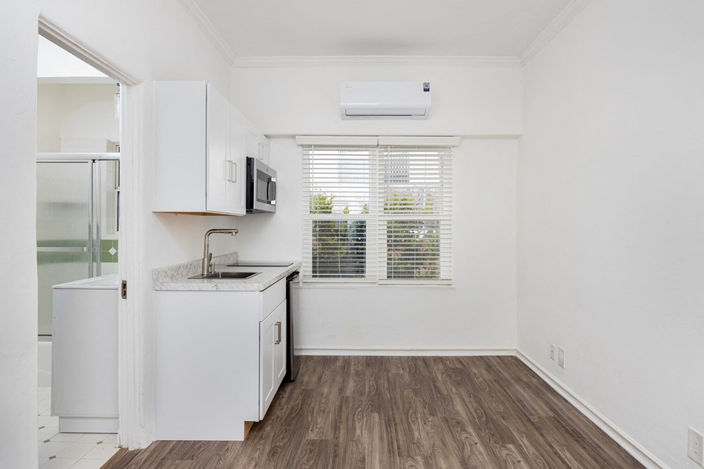 an empty room with a kitchen and a window