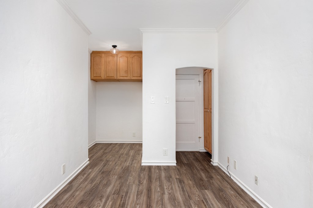 an empty living room with white walls and wood flooring