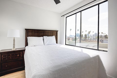 a bedroom with a large window and a bed