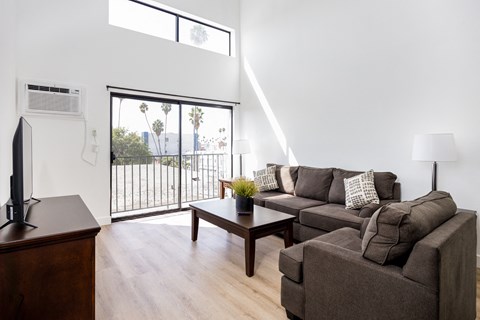 a living room with a couch and a coffee table and a balcony