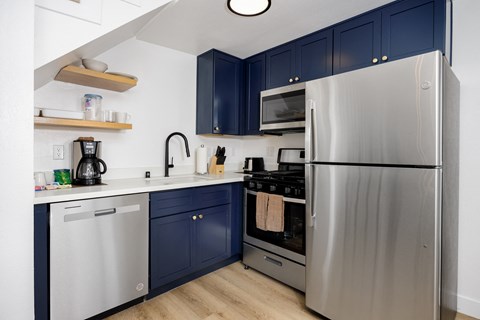 a kitchen with stainless steel appliances and blue cabinets