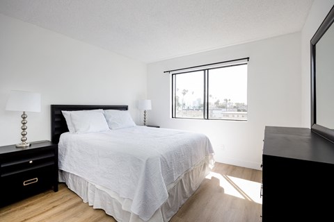 a bedroom with a bed and a large window