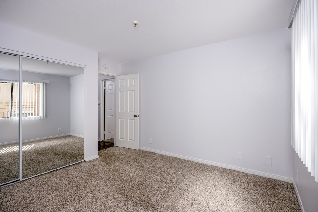A room with a carpeted floor and a sliding glass door.