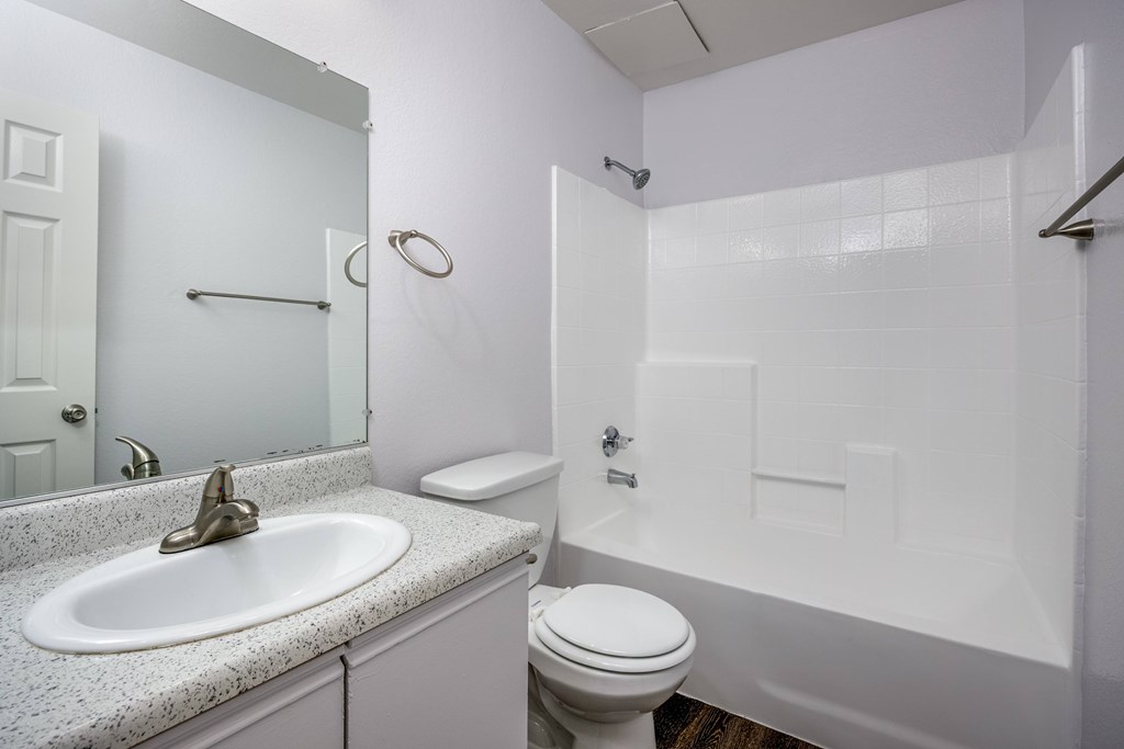 A white bathroom with a sink, toilet, and bathtub.