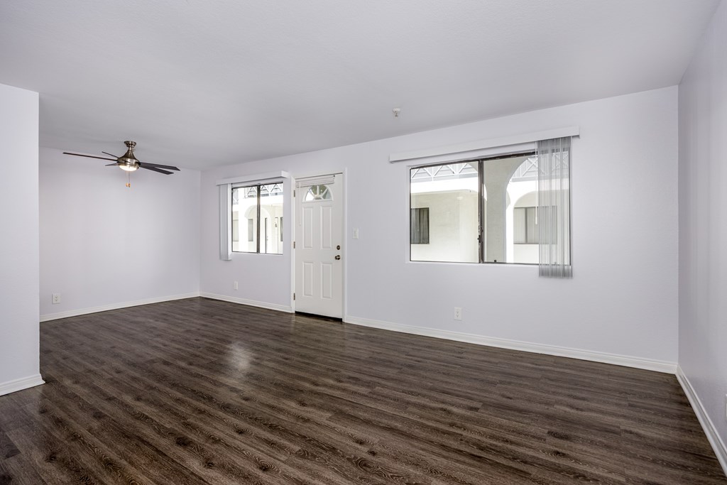 A room with a wooden floor and a ceiling fan.
