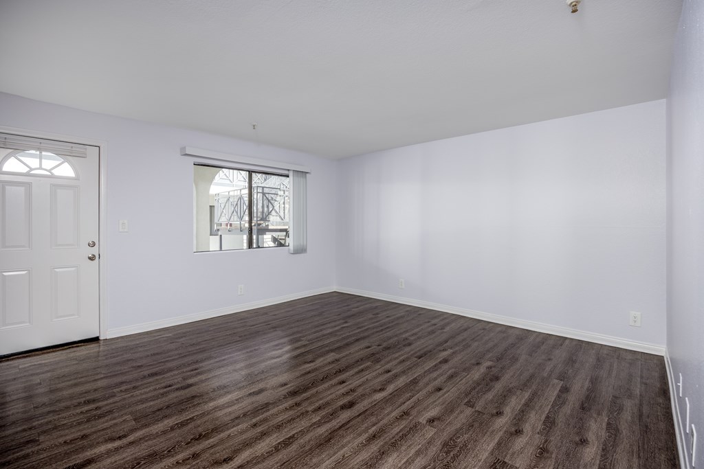 A room with wooden flooring and a window.