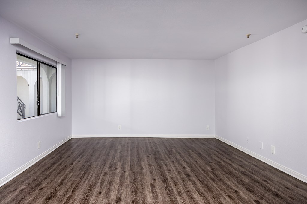 A room with wooden flooring and a window.