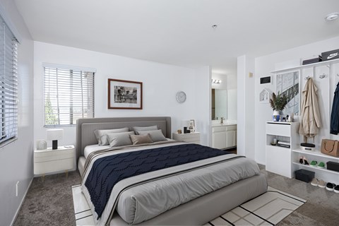 A bedroom with a large bed and a clothing rack.