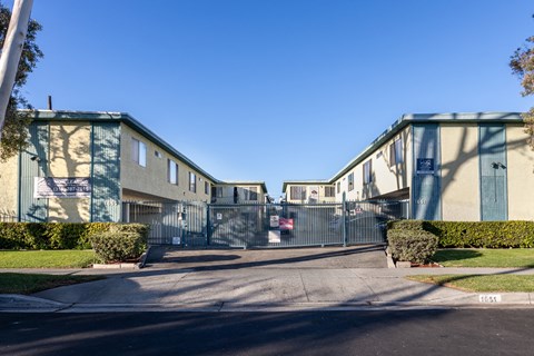 A street view of a residential area with houses on both sides and a car parked in the middle.