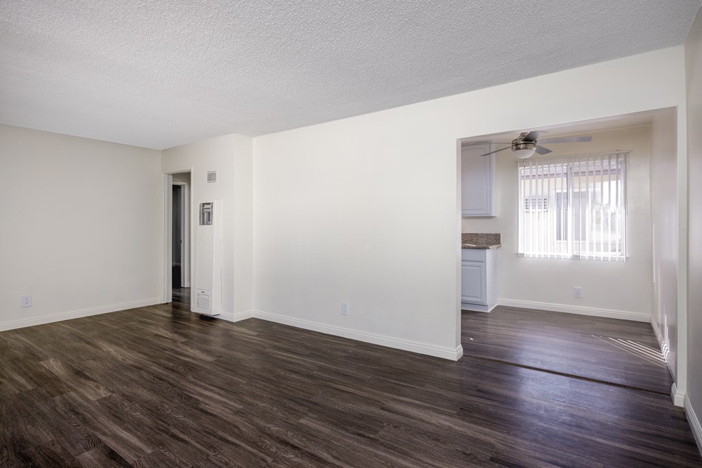 an empty living room with white walls and wood flooring