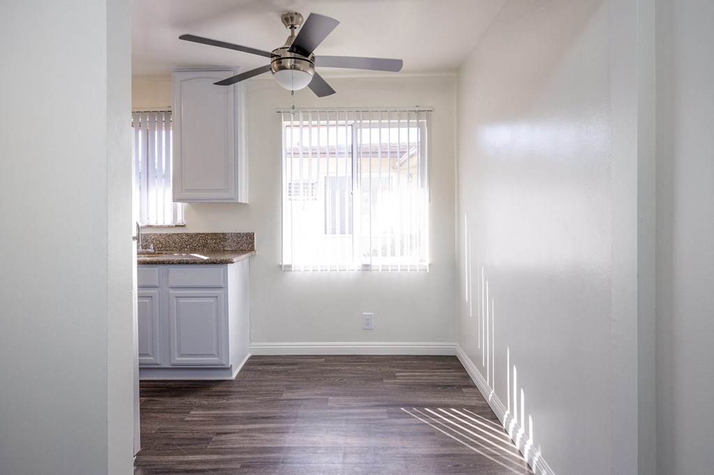 an empty kitchen with a ceiling fan and a window