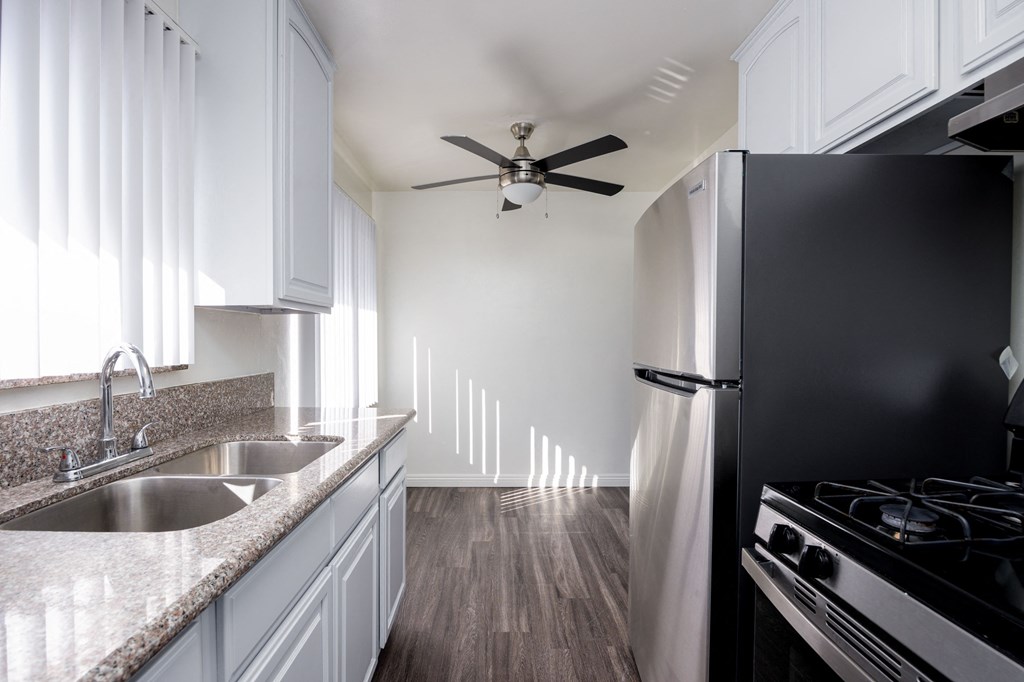 a kitchen with white cabinets and a sink and a refrigerator