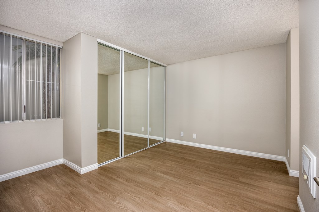 A room with a sliding glass door and wooden flooring.