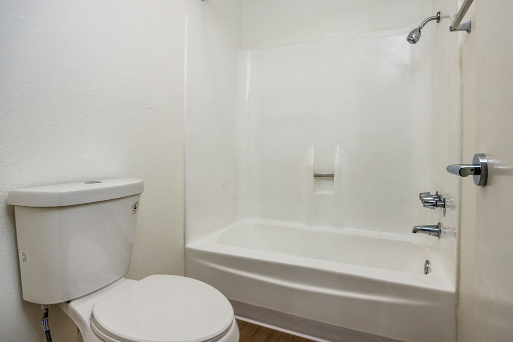 A white toilet and bathtub in a bathroom.