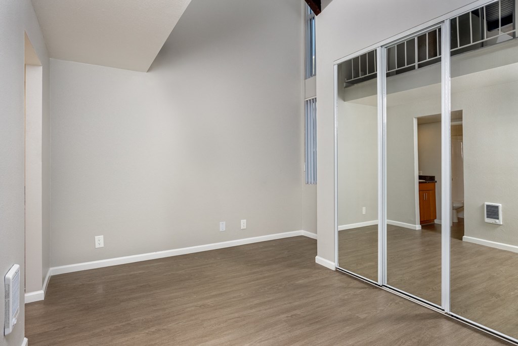 A room with a white wall and wooden floor.