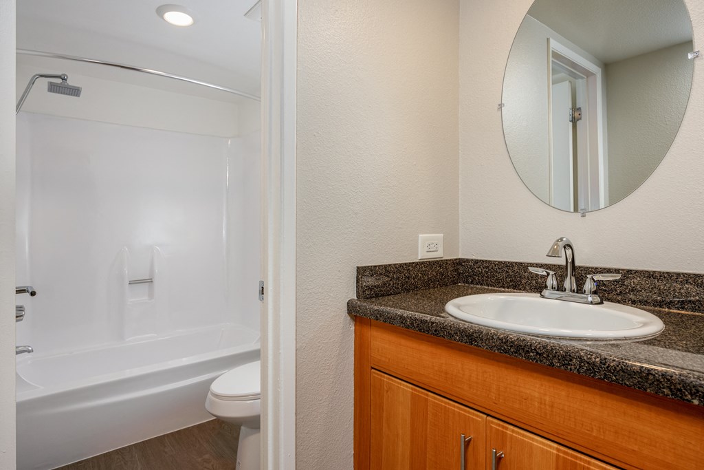 A bathroom with a white tub and sink.