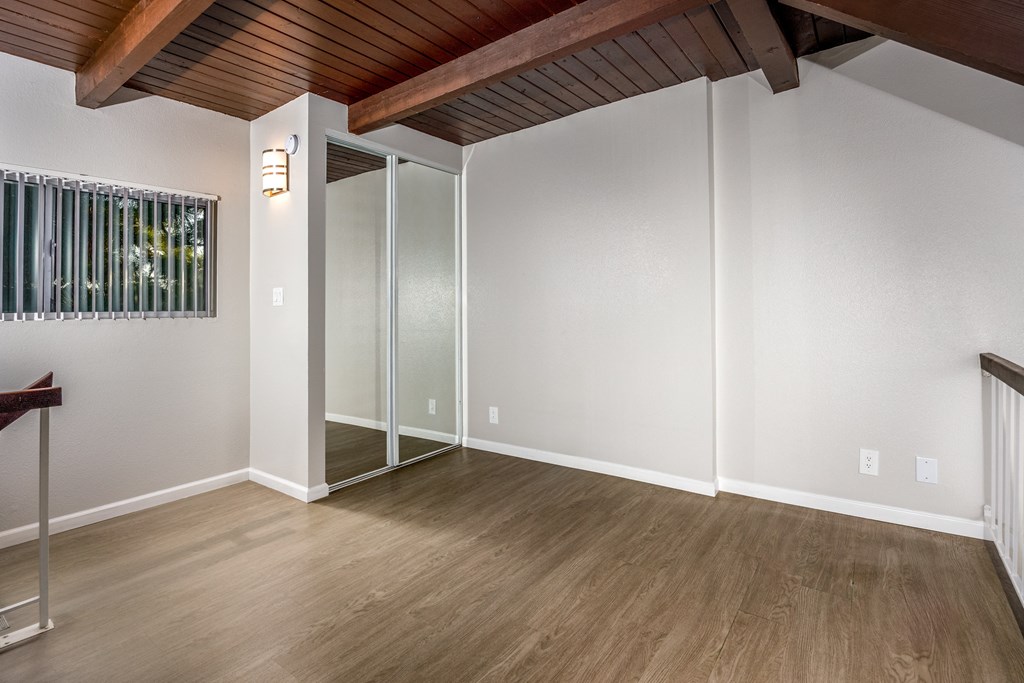 A room with a wooden ceiling and a glass door.