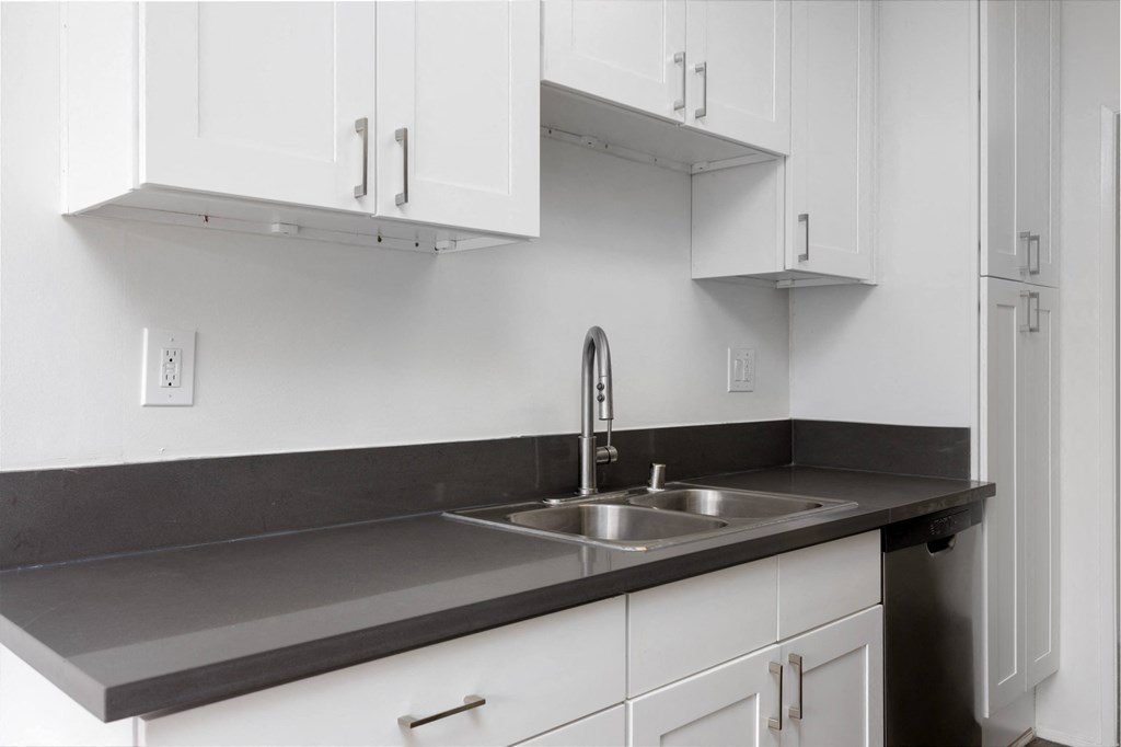a kitchen with white cabinets and a sink