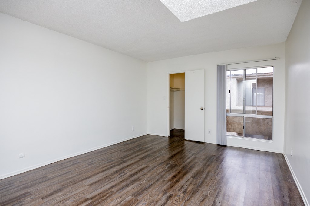 an empty living room with wood floors and white walls