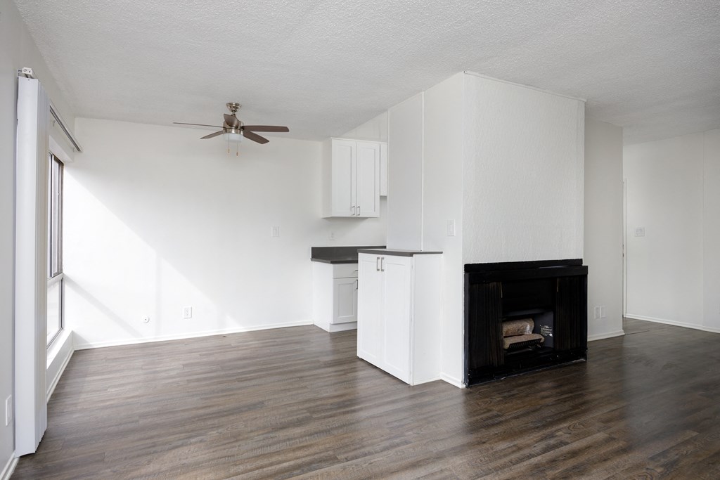 an empty living room with white walls and a fireplace