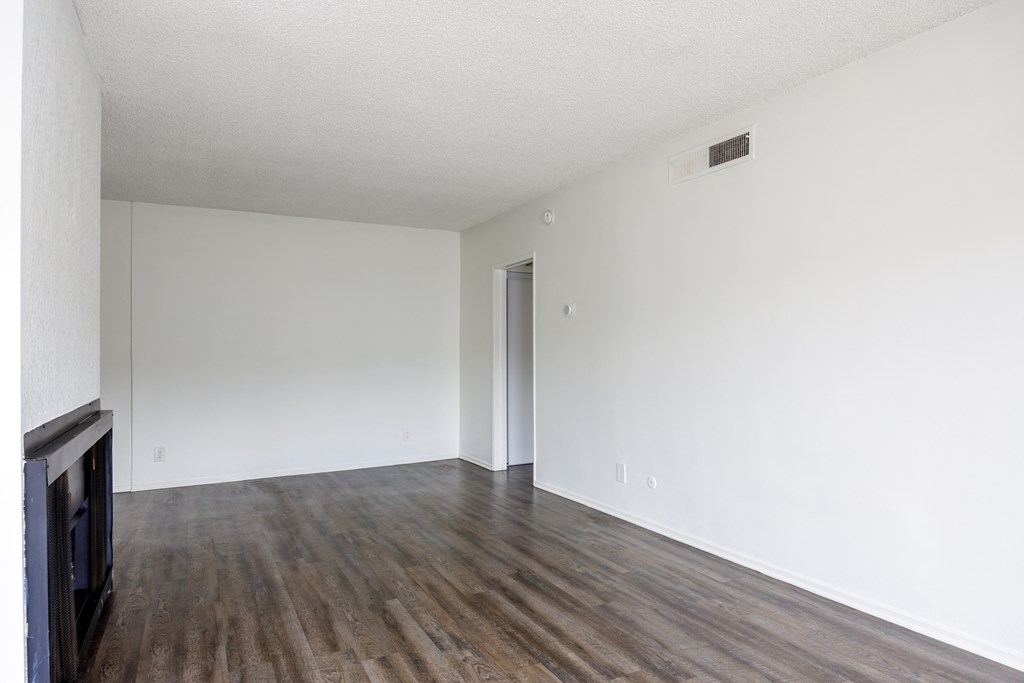 an empty living room with white walls and wood floors