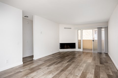 an empty living room with wood floors and a fireplace