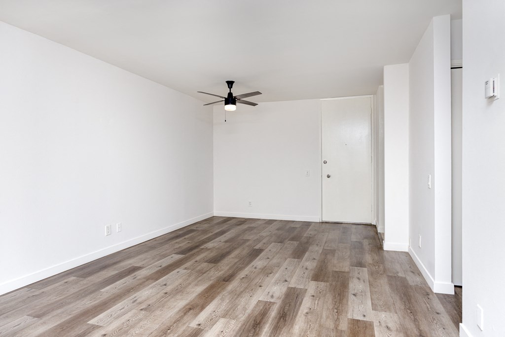 a bedroom with hardwood floors and white walls