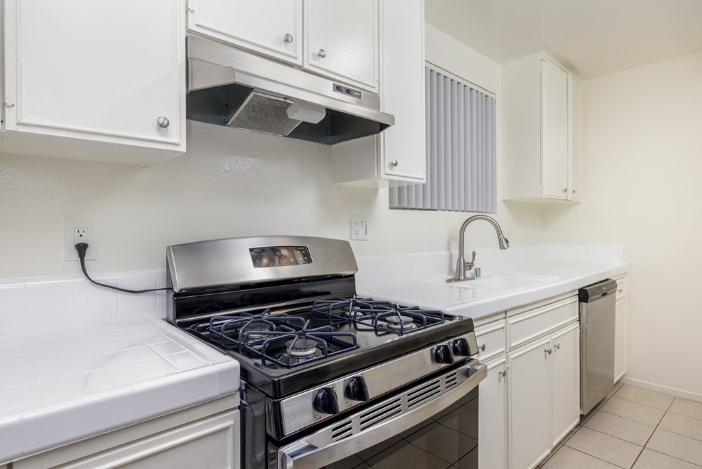 a kitchen with white cabinets and a black stove top oven