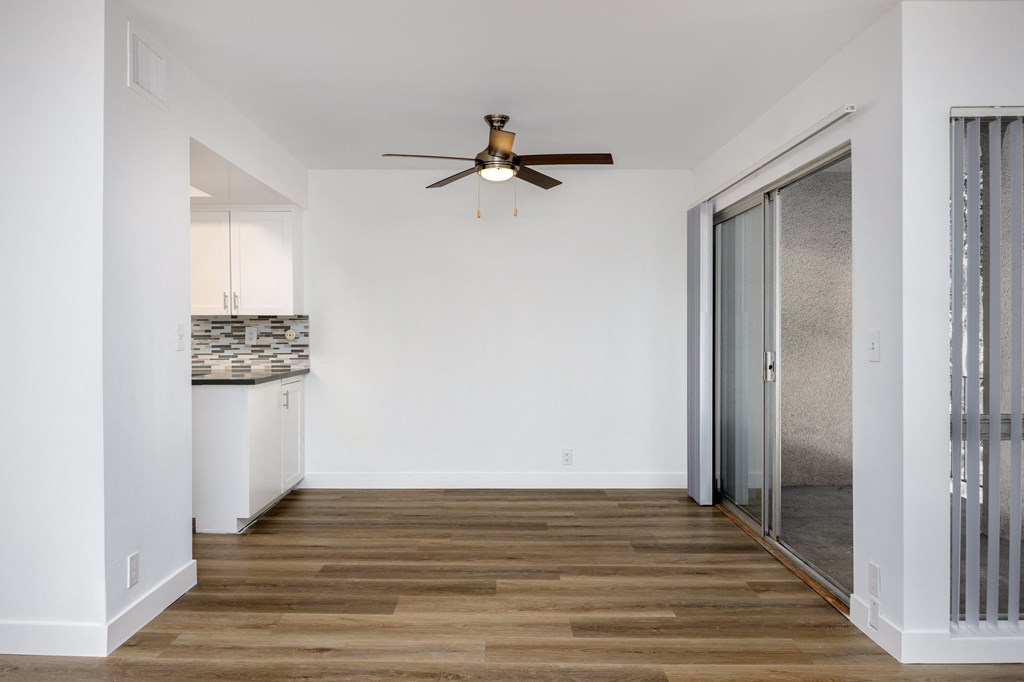 a hallway with a ceiling fan and a door to a kitchen