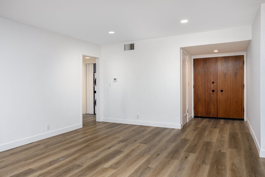 a living room with white walls and a wooden door