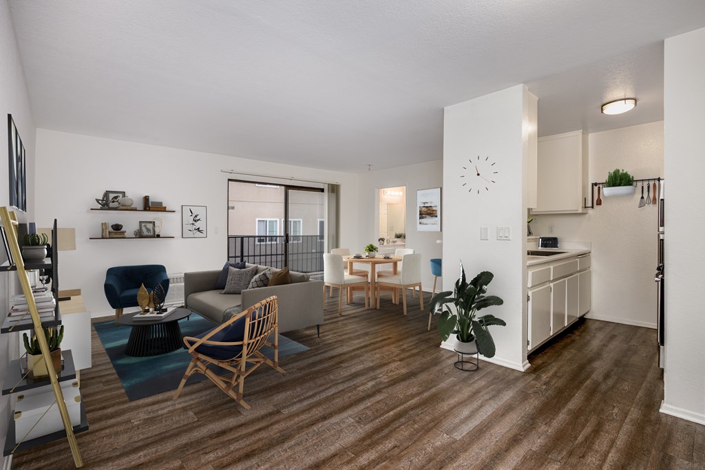 A living room with a couch, chair, and potted plant.