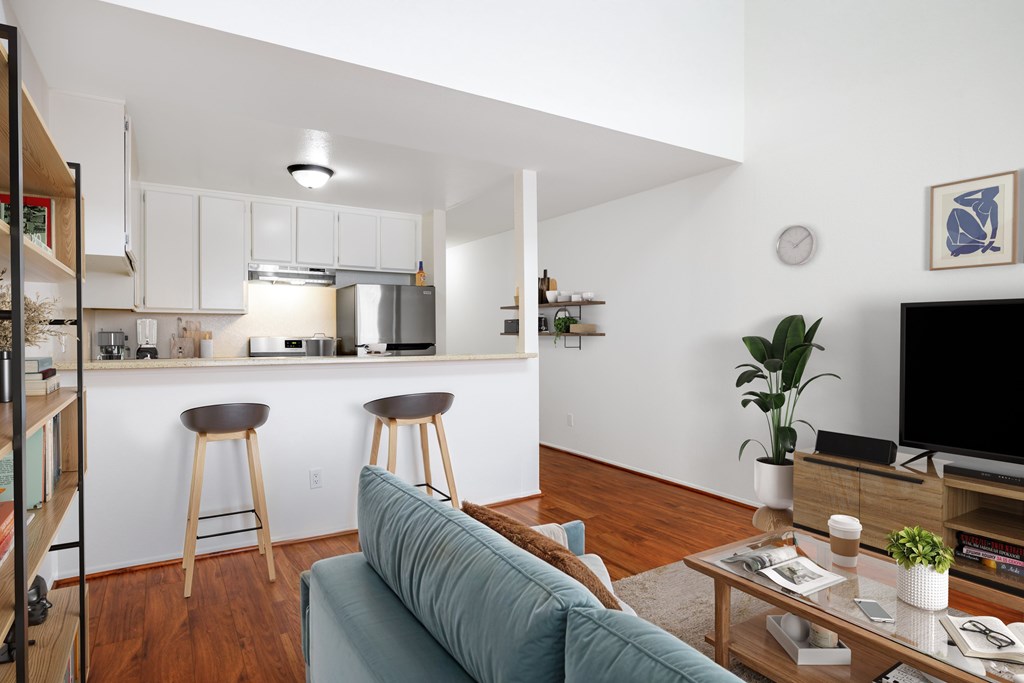 A living room with a blue couch and a wooden floor.
