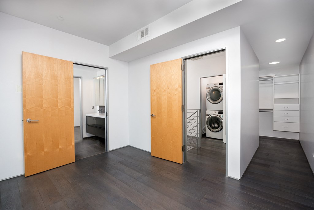 a living room with a door to a laundry room and a washing machine