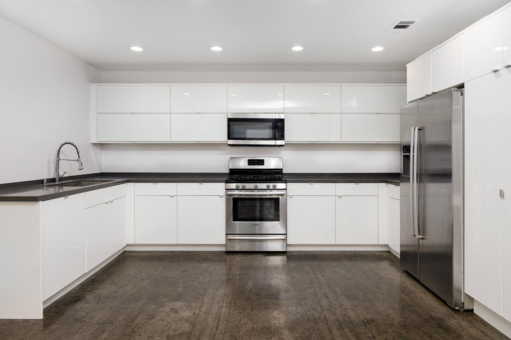 a kitchen with white cabinets and stainless steel appliances