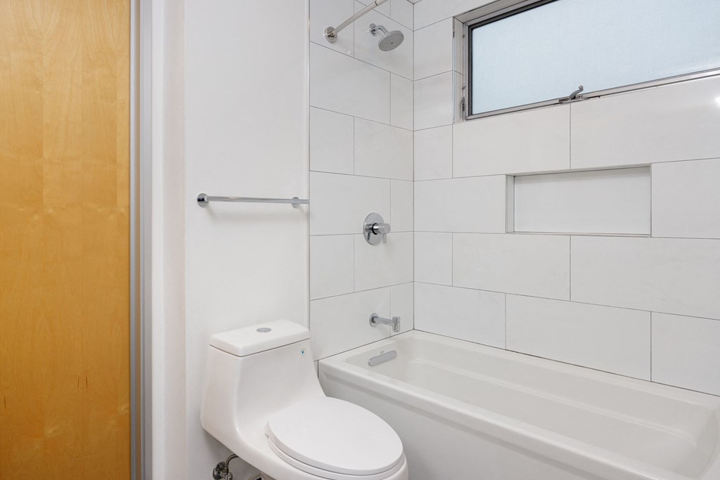 a bathroom with a white toilet and a tub