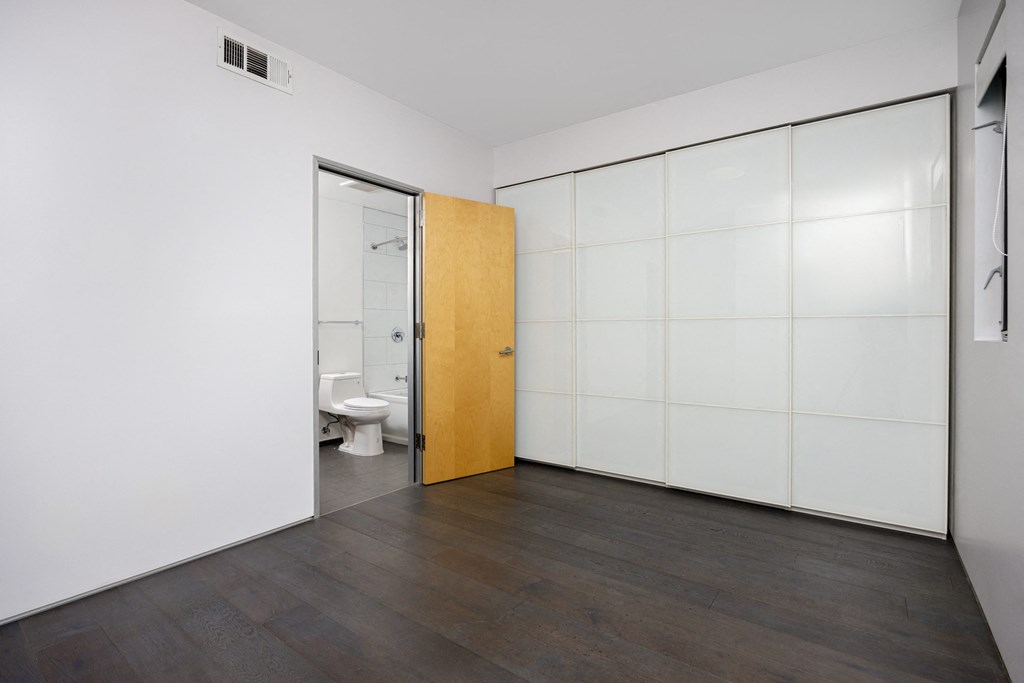 a white bathroom with a toilet and a door