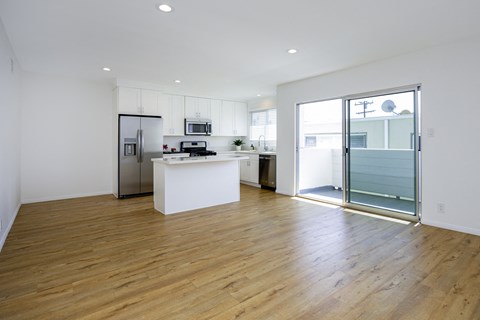 a living room with a kitchen and a sliding glass door