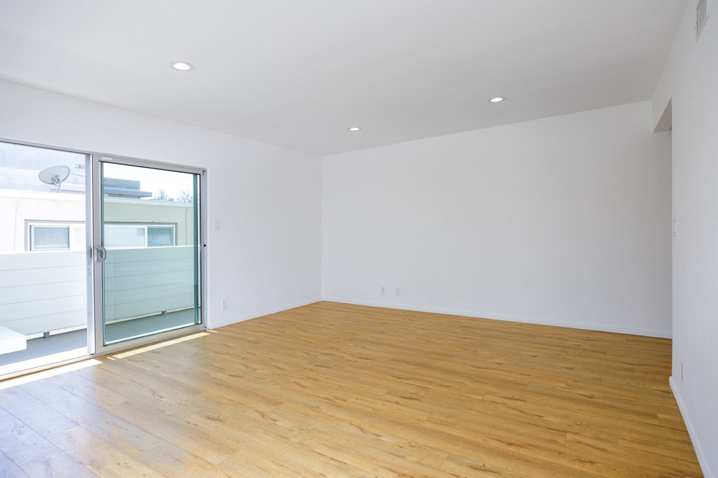 a living room with white walls and a sliding glass door