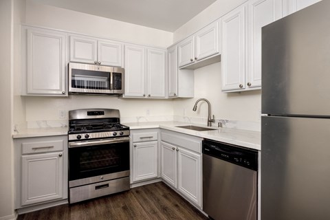 A kitchen with white cabinets and stainless steel appliances.