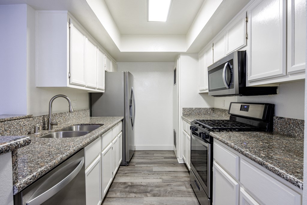 A kitchen with granite countertops and stainless steel appliances.