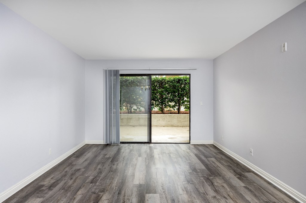 A room with a sliding glass door leading to a patio.