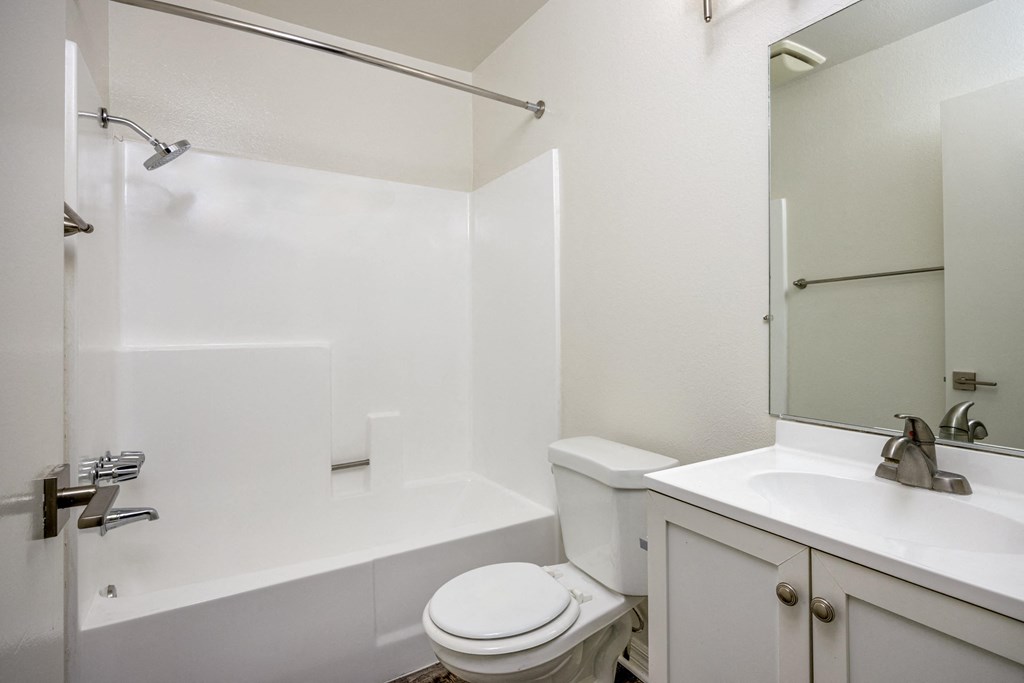 A white bathroom with a toilet, sink, and bathtub.