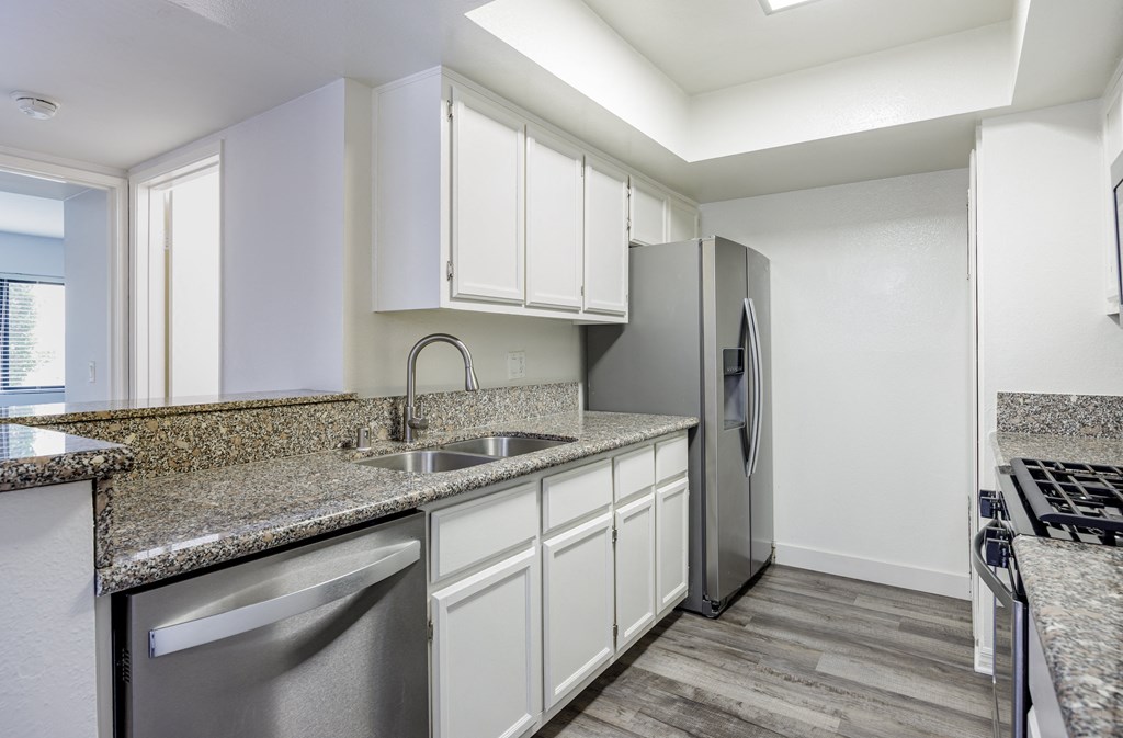 A kitchen with a granite countertop and stainless steel appliances.