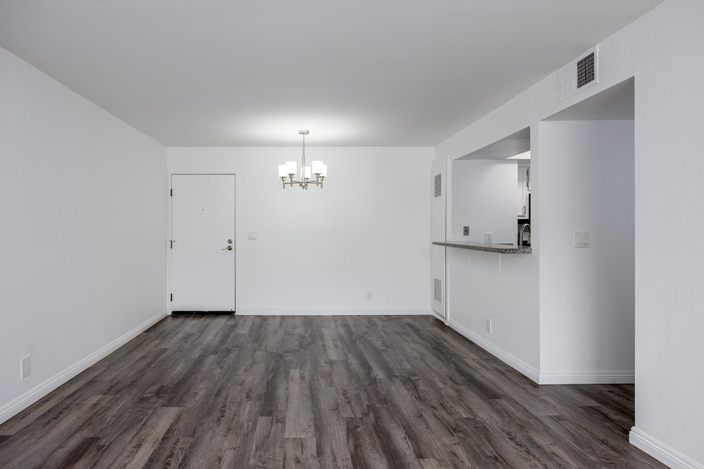 A room with wooden flooring and white walls.