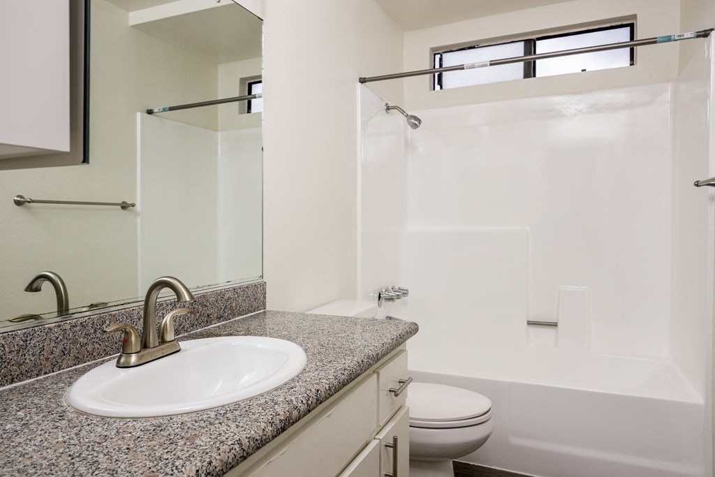 A bathroom with a sink, toilet, and shower.