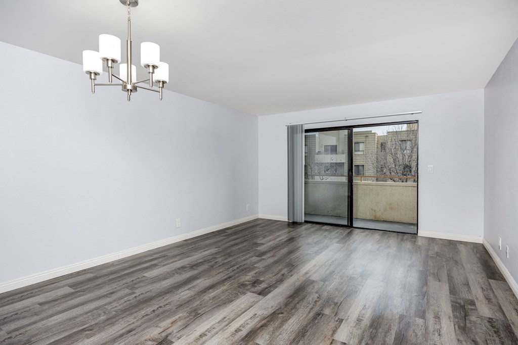 A room with a chandelier and a sliding glass door.