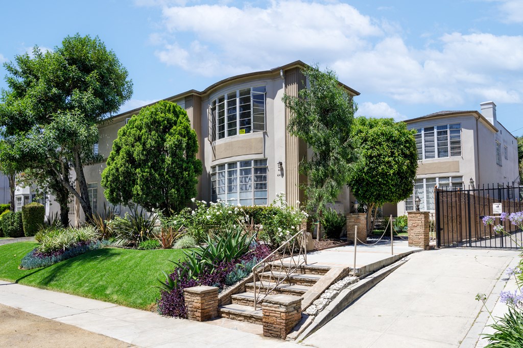 a house with stairs and a sidewalk in front of it