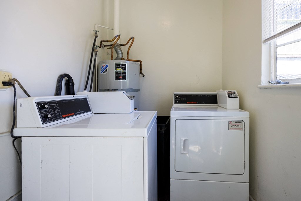 a laundry room with a washer and dryer and a window and a refrigerator
