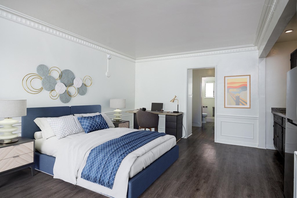 a bedroom with a bed and a desk in a hotel room